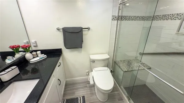 a white toilet sitting next to a bathroom sink and a shower