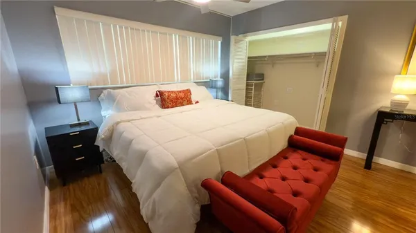 a bedroom with bed and wooden floor