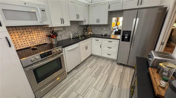a kitchen with white cabinets and white appliances