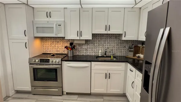 a kitchen with white cabinets and stainless steel appliances