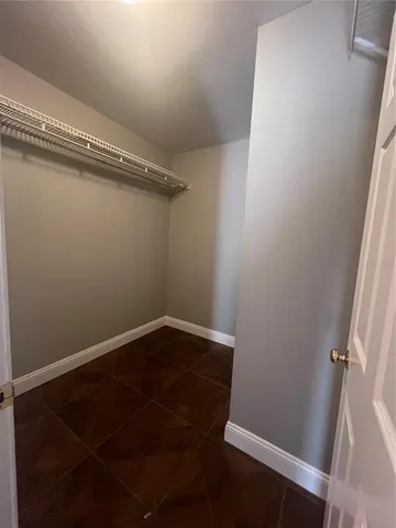 a view of a room with wooden floor and small window
