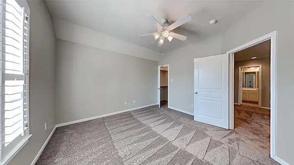 an empty room with fan and windows