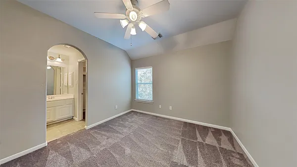 an empty room with windows and fan