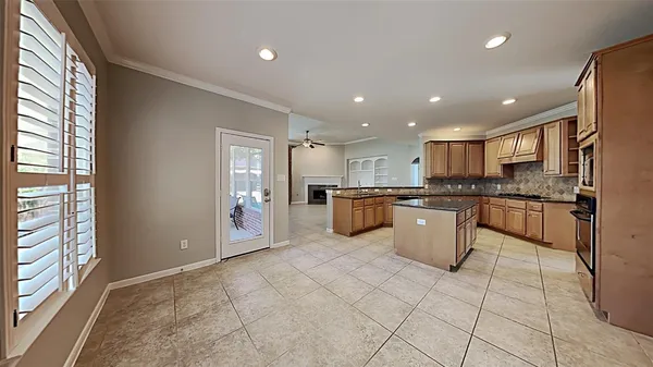 a large kitchen with stainless steel appliances granite countertop a large counter top and a view of living room