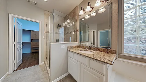 a bathroom with a granite countertop sink a large mirror and a shower