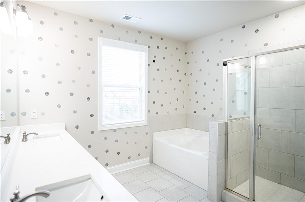 2215 Manor Pointe Drive Cumming, GA 30041 - Photo 11 of 25 a bathroom with a bathtub and a shower