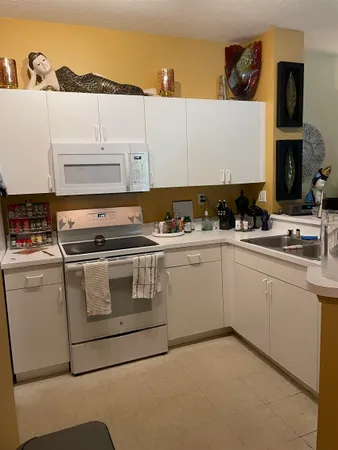 a kitchen with white cabinets and white appliances