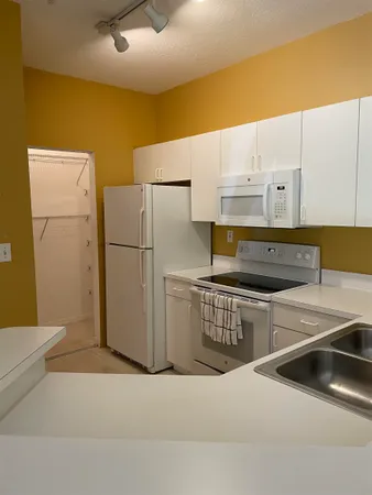a kitchen with white cabinets and white appliances