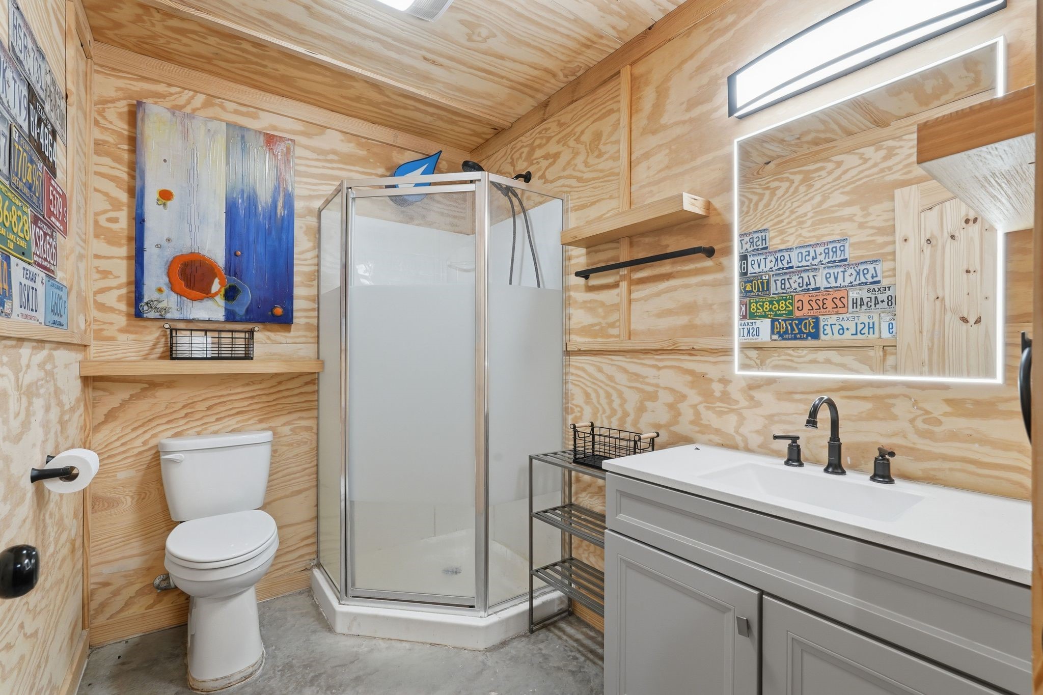 2743 Bobville Road Montgomery, TX 77316 - Photo 50 of 50 This bathroom features a modern, rustic design with plywood walls, a sleek corner shower, and a stylish vanity in the shop area.