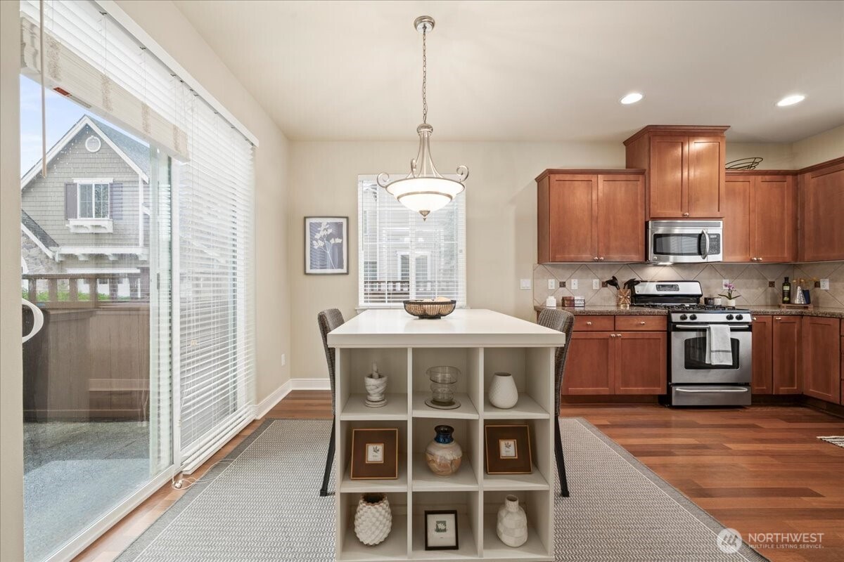 18213 36th Avenue Southeast Bothell, WA 98012 - Photo 9 of 34 a kitchen with stainless steel appliances granite countertop a stove a sink dishwasher a refrigerator with a dining table and chairs