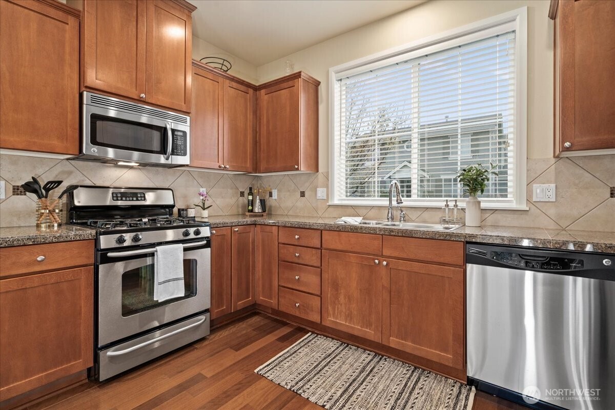 18213 36th Avenue Southeast Bothell, WA 98012 - Photo 10 of 34 a kitchen with stainless steel appliances granite countertop a stove a sink and a microwave