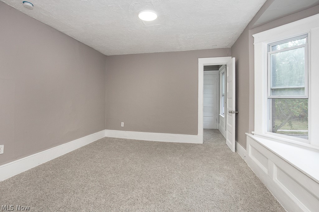 1892 Beersford Road Cleveland, OH 44112 - Photo 24 of 47 Carpeted spare room with a wealth of natural light and a textured ceiling