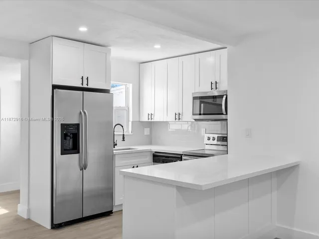 a kitchen with stainless steel appliances a refrigerator sink and microwave