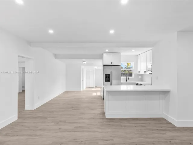 a view of kitchen with stainless steel appliances a sink and a refrigerator