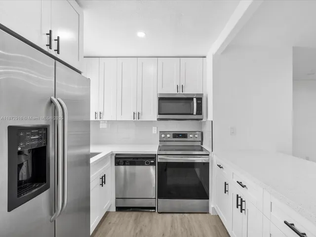 a kitchen with stainless steel appliances a stove microwave and a refrigerator
