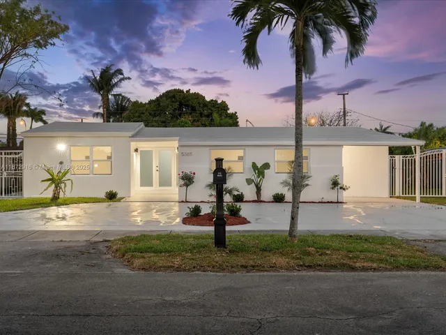 a front view of a house with garden and plants
