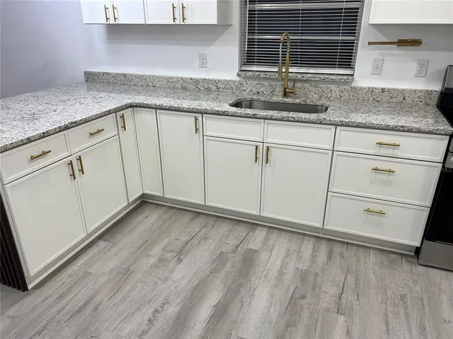 a kitchen with granite countertop white cabinets and white appliances