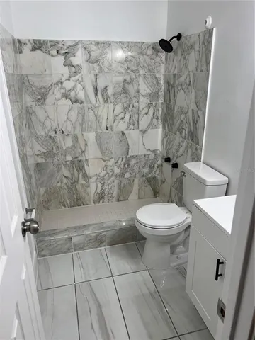 a bathroom with a toilet and a shower