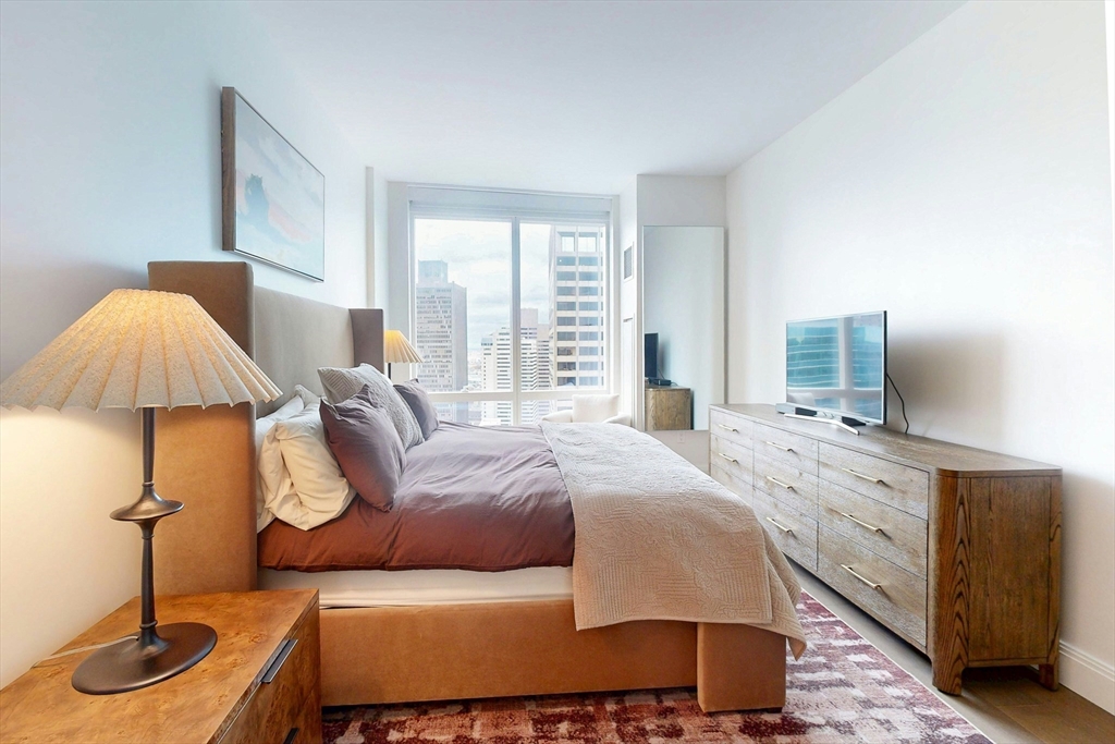 240 Devonshire Street, Unit U3814 Boston, MA 02110 - Photo 6 of 40 a bedroom with a bed and wooden floor