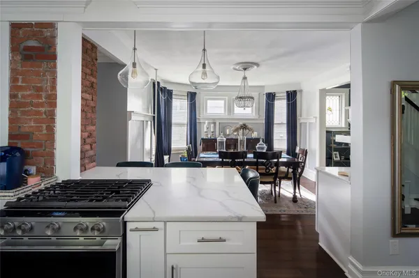 a kitchen with a stove a sink and chairs