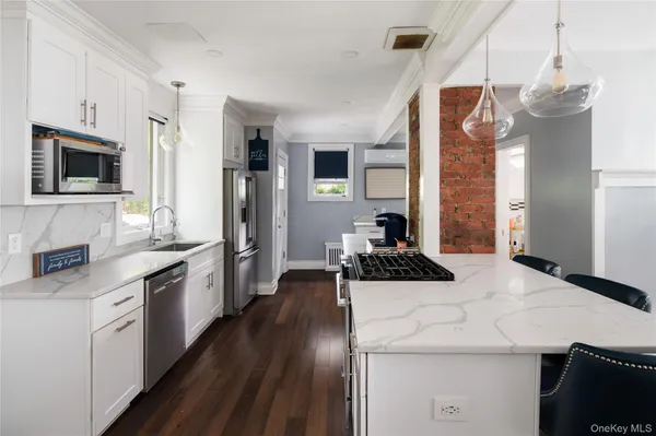a kitchen with stainless steel appliances a stove sink microwave and cabinets