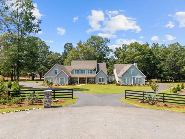a view of a house with a big yard and large trees