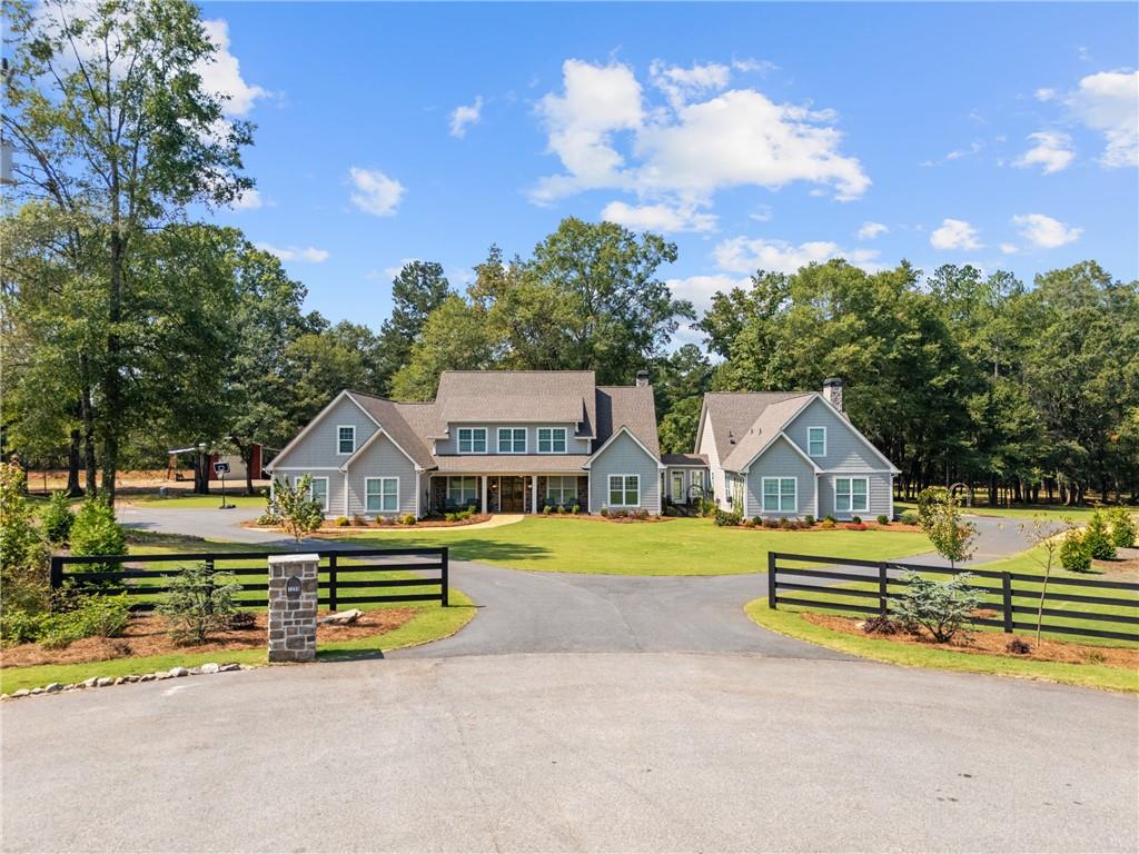 a view of a house with a big yard and large trees