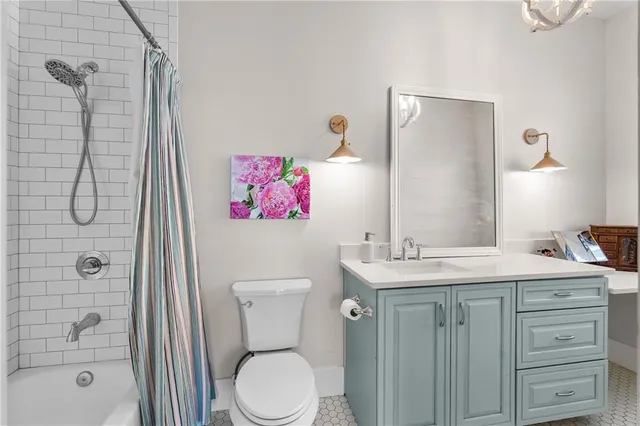 a bathroom with a toilet sink vanity shower and mirror