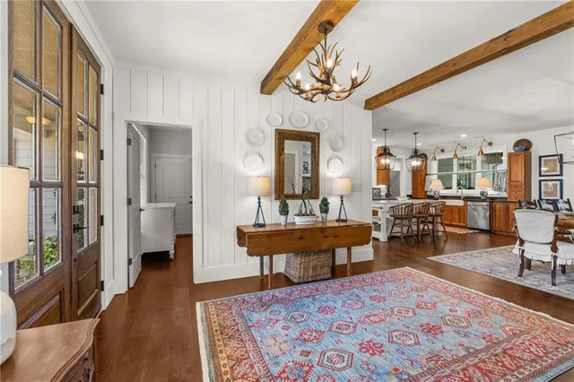 a dining room with wooden floor and a chandelier