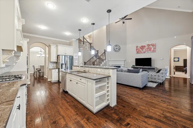 a kitchen with stainless steel appliances granite countertop a stove and a living room