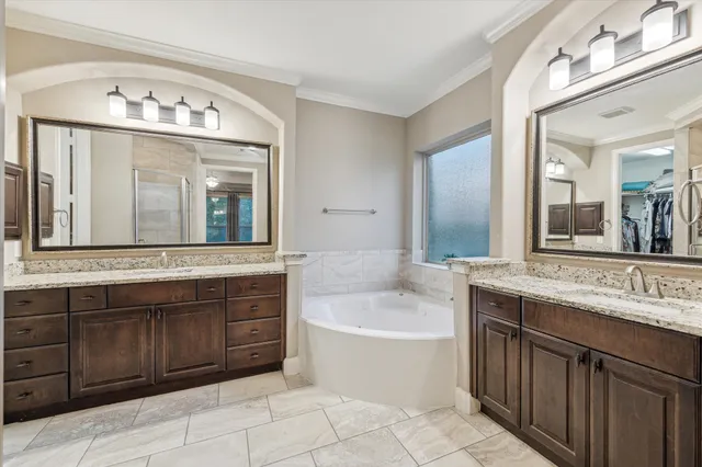 a spacious bathroom with a tub sink and mirror