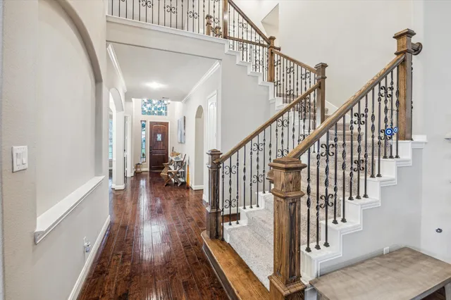 a view of staircase with lots of frames on wall and wooden floor