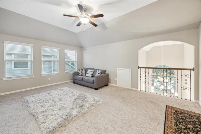 a spacious bedroom with a large bed and a chandelier