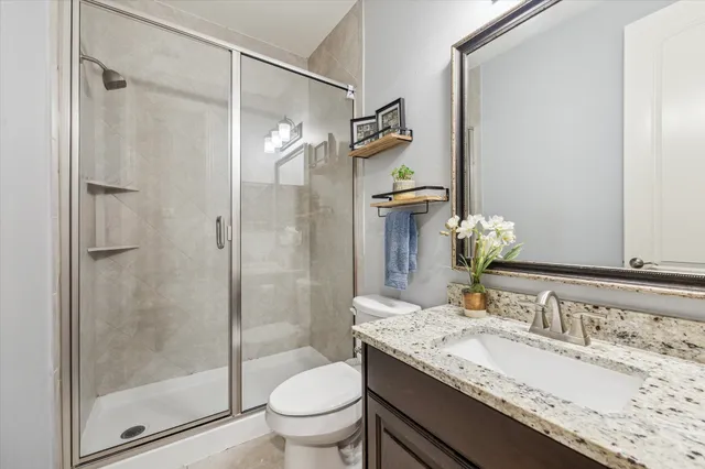 a bathroom with a granite countertop sink toilet and shower