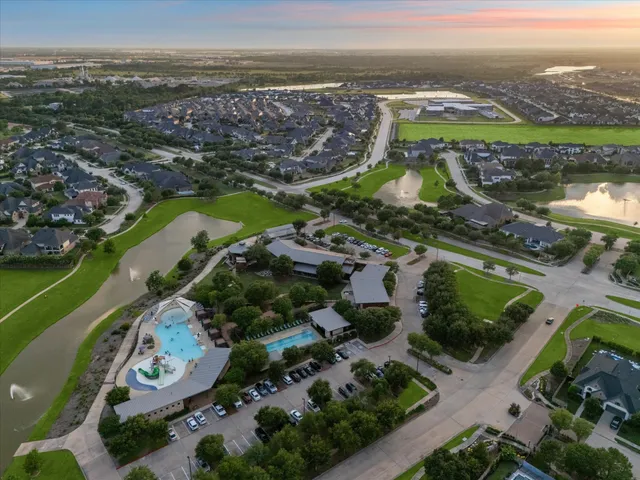 an aerial view of ocean and residential houses with outdoor space