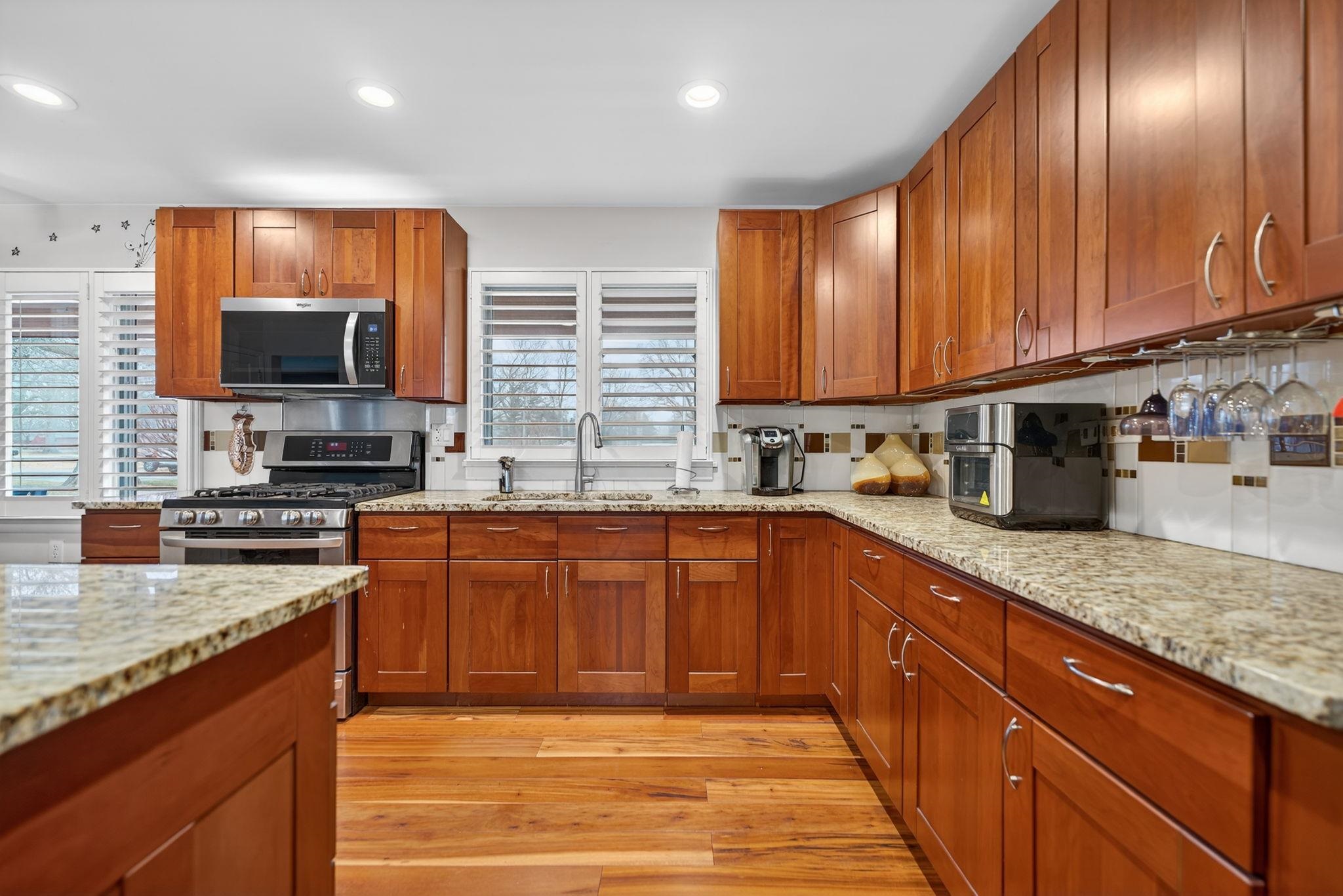 7681 Mill Road Rockford, IL 61108 - Photo 15 of 43 a kitchen with stainless steel appliances granite countertop wooden cabinets a stove top oven a granite counter and a sink