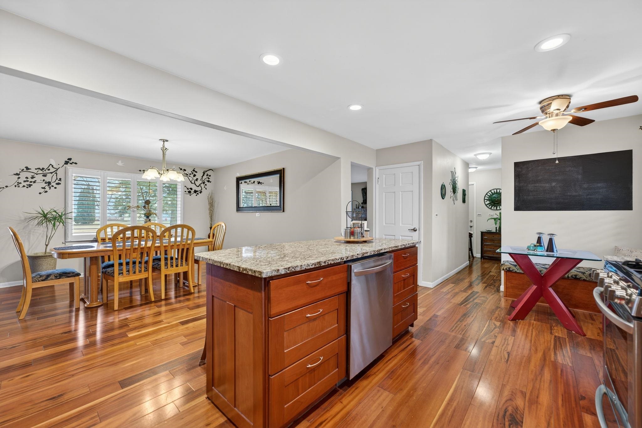 7681 Mill Road Rockford, IL 61108 - Photo 18 of 43 a kitchen with stainless steel appliances granite countertop a stove top oven a dining table and chairs with wooden floor