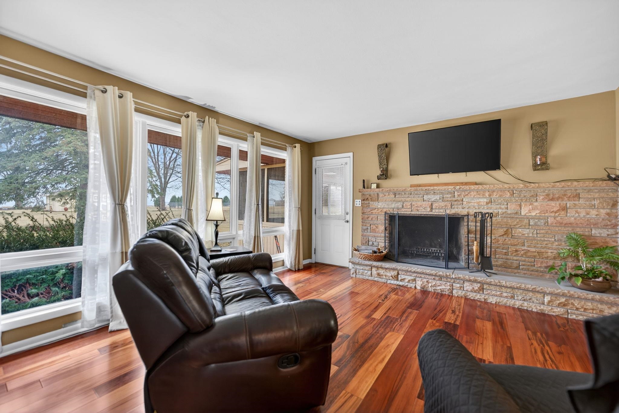 7681 Mill Road Rockford, IL 61108 - Photo 21 of 43 a living room with furniture a flat screen tv and a fireplace