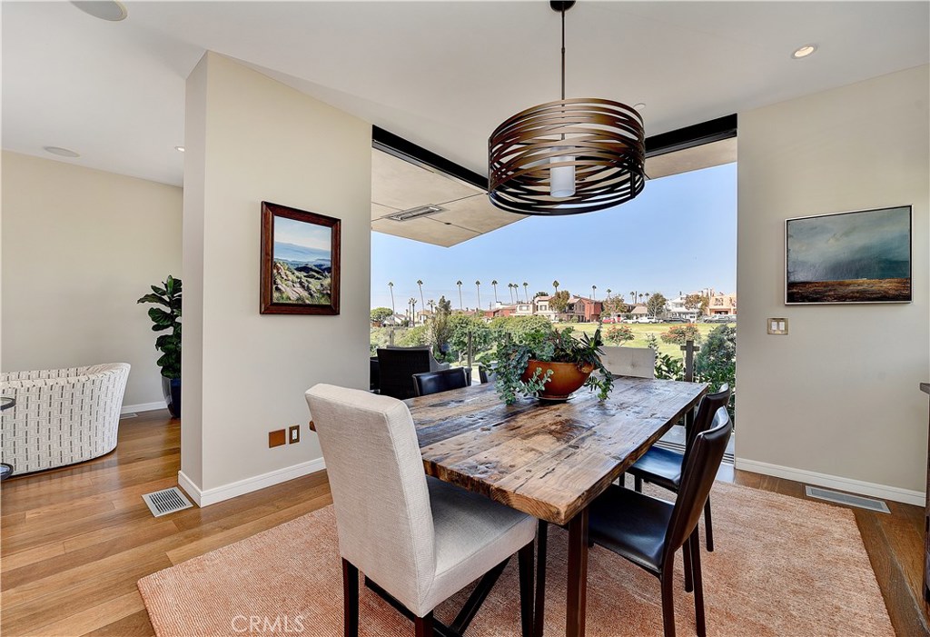 418 Carnation Avenue Corona del Mar, CA 92625 - Photo 11 of 29 a view of a dining room with furniture wooden floor and chandelier