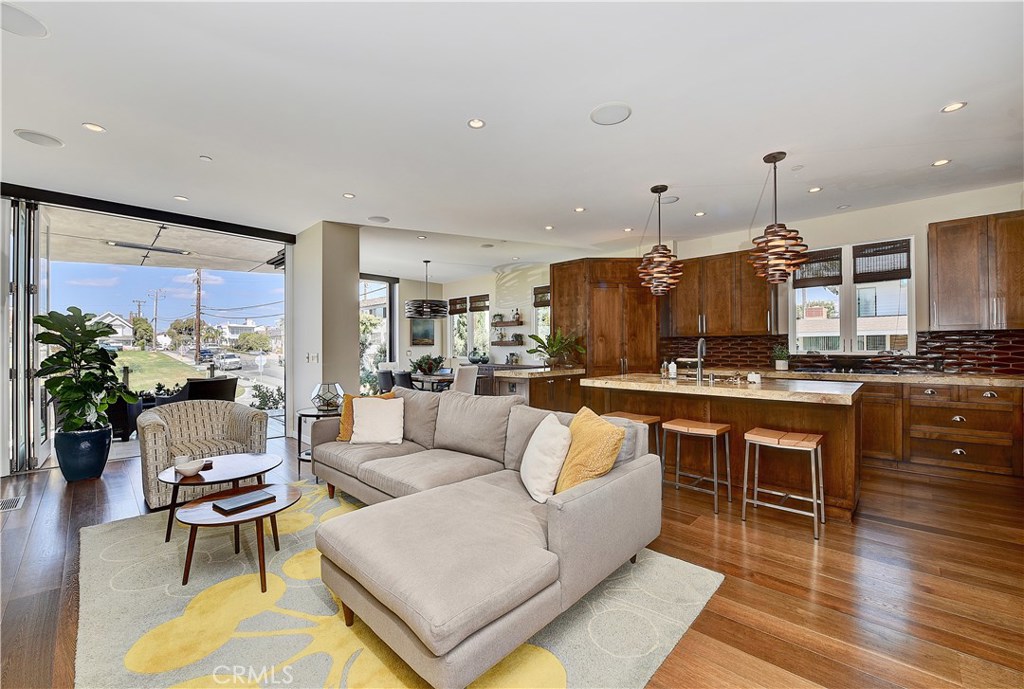418 Carnation Avenue Corona del Mar, CA 92625 - Photo 2 of 29 a living room with stainless steel appliances kitchen island granite countertop a couch a dining table and a large window