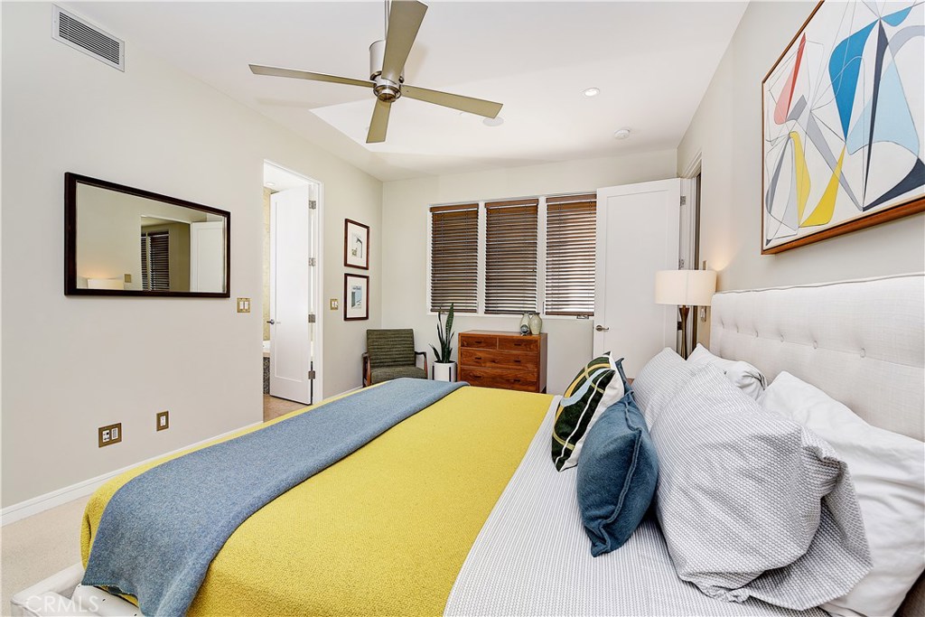 418 Carnation Avenue Corona del Mar, CA 92625 - Photo 21 of 29 a spacious bedroom with a bed and a painting on the wall