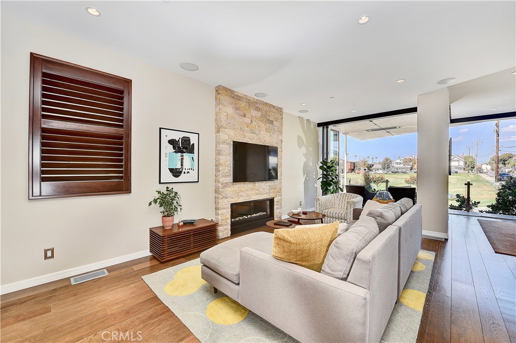 418 Carnation Avenue Corona del Mar, CA 92625 - Photo 7 of 29 a living room with furniture a flat screen tv and a fireplace