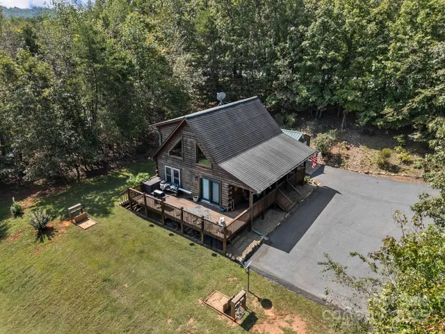 an aerial view of a house with swimming pool and large trees