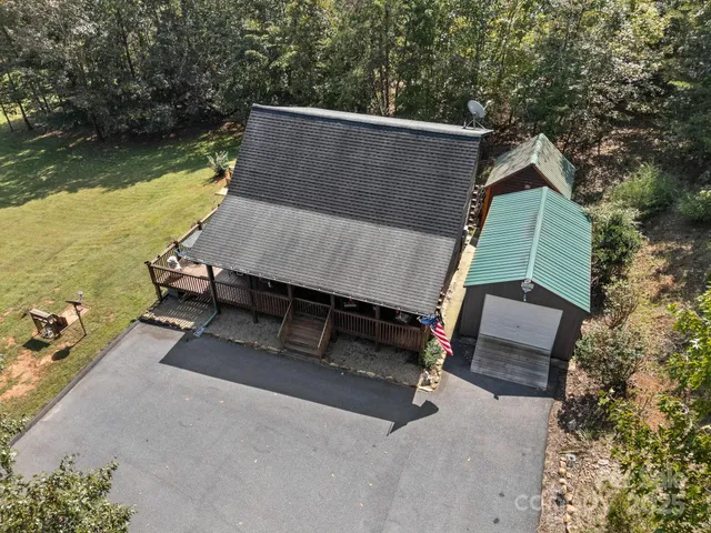 an aerial view of a house with swimming pool and outdoor seating