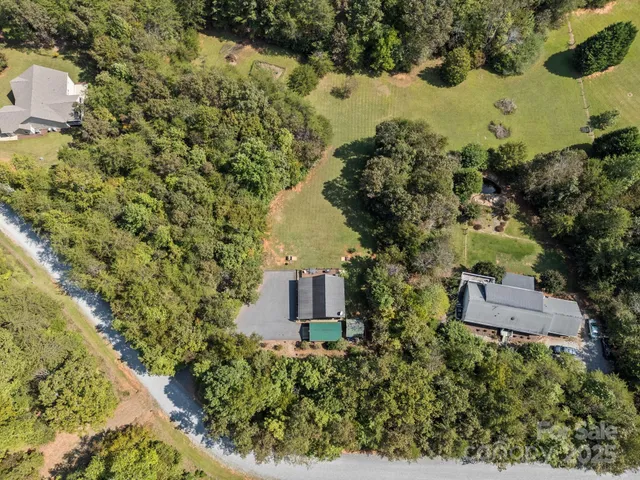 an aerial view of a house with a yard and lake view