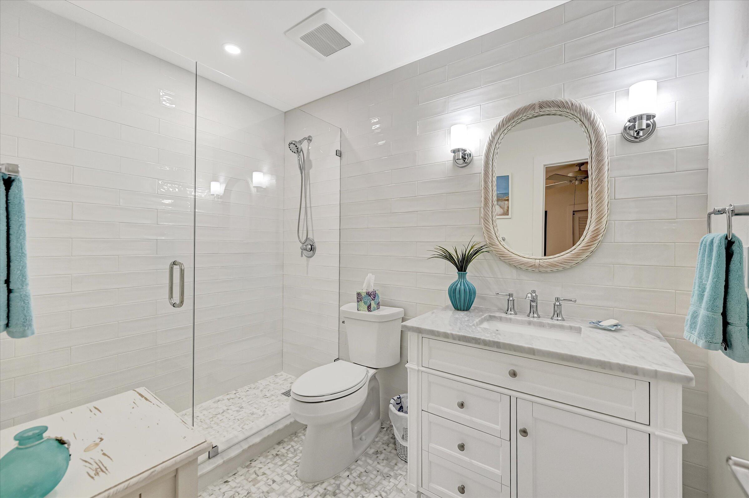 535 Augusta Boulevard, Unit 4 Naples, FL 34113 - Photo 38 of 44 a bathroom with a toilet a sink a mirror and vanity