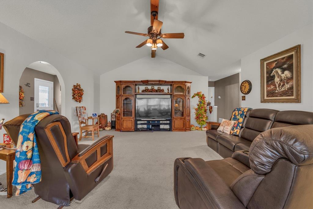 107 Fort Graham Circle Waco, TX 76705 - Photo 11 of 39 Living area with lofted ceiling, light carpet, and ceiling fan