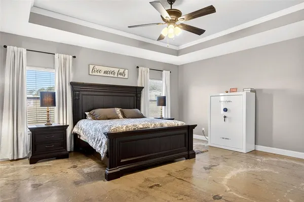 a spacious bedroom with a bed and a ceiling fan