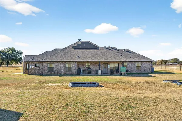 a front view of a house with a yard and swimming pool