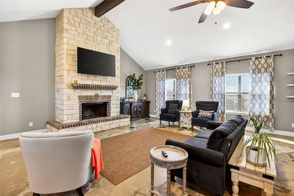 a living room with furniture a fireplace and a flat screen tv